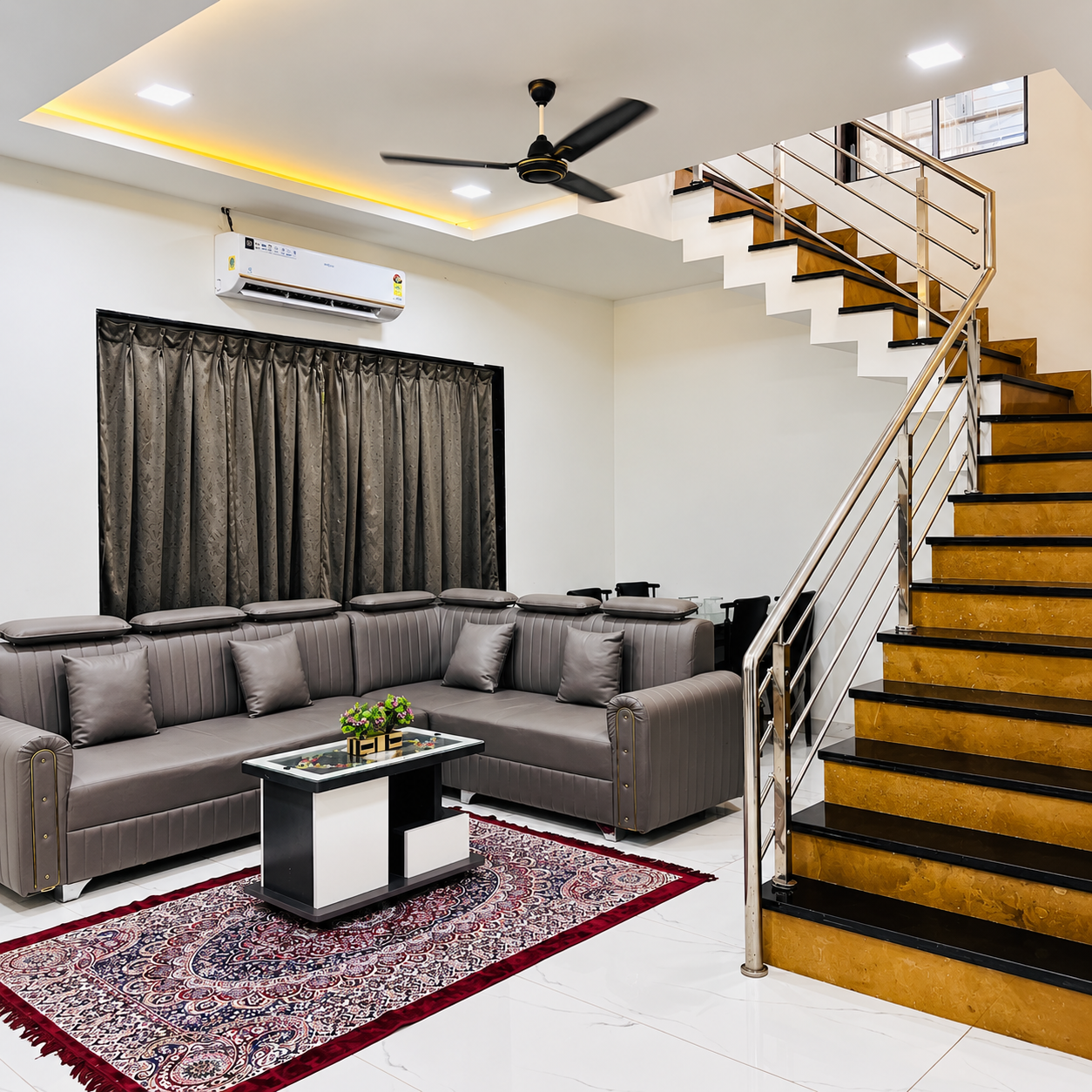 Spacious living lounge with sectional sofa and staircase at Saanjh villa
