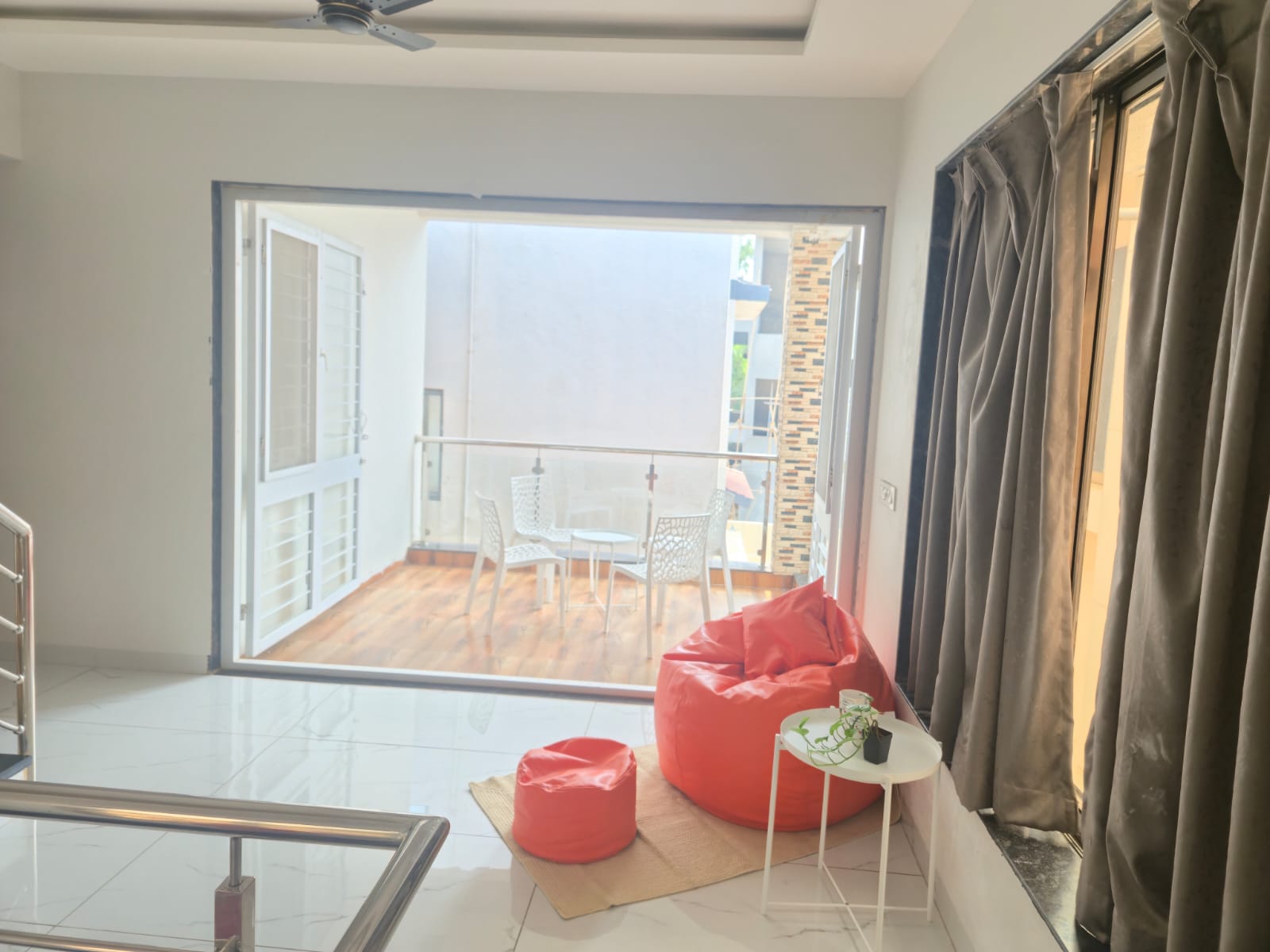 Saanjh villa upper level lounge with bean bag seating and balcony access